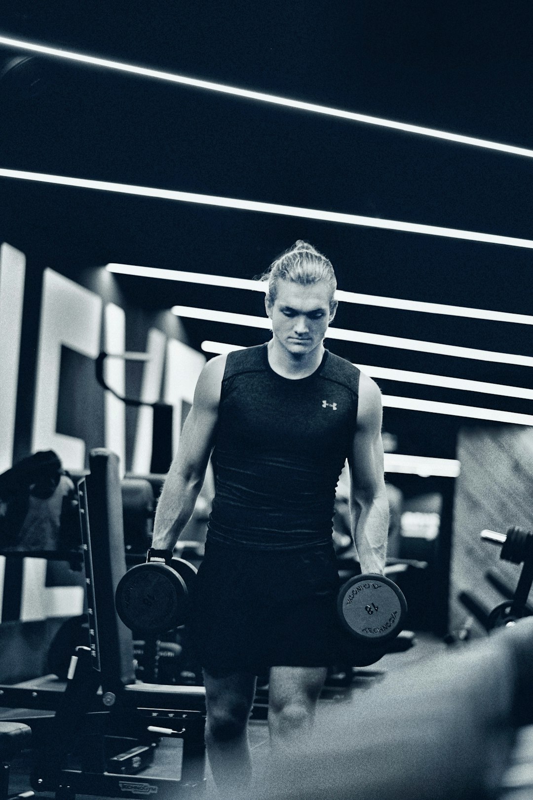 a-man-holding-a-pair-of-dumbs-in-a-gym-j75hrxxwarg